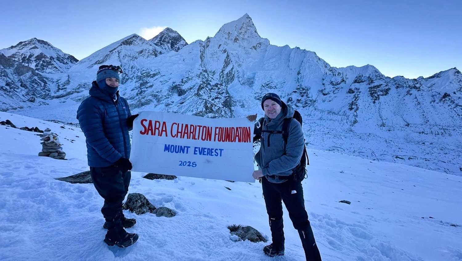 Leonard Charlton holding the Sara Charlton Foundation banner at Kala Patthar, near Mount Everest